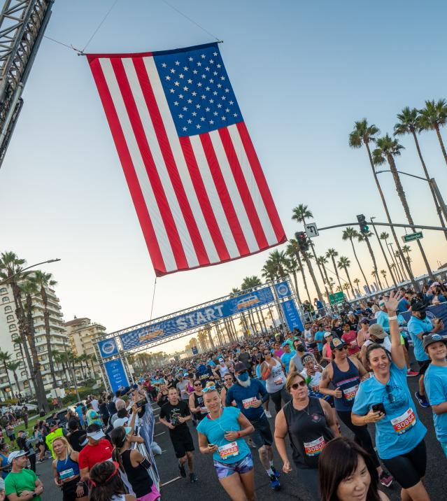Surf City Marathon Start Line with Runners and an American Flag over the start line